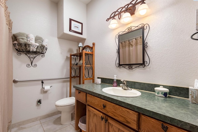 bathroom with tile patterned flooring, vanity, and toilet