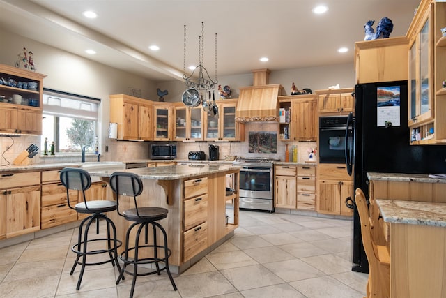 kitchen with stainless steel stove, a center island, light stone counters, a kitchen bar, and oven