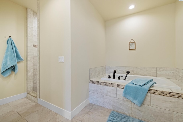 bathroom with tiled bath and tile patterned flooring