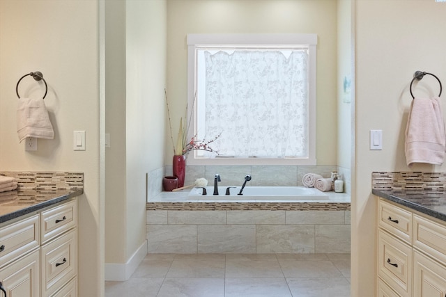 bathroom featuring vanity, tiled tub, decorative backsplash, and tile patterned floors