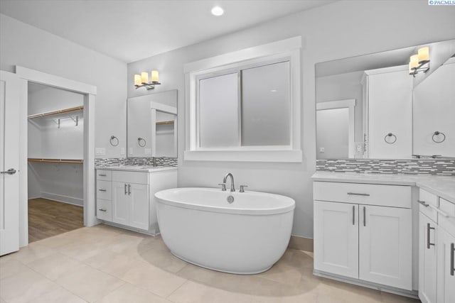 3149 Wild Canyon Way, Richland, WA 99354 - bathroom with a freestanding tub, two vanities, a spacious closet, baseboards, and recessed lighting