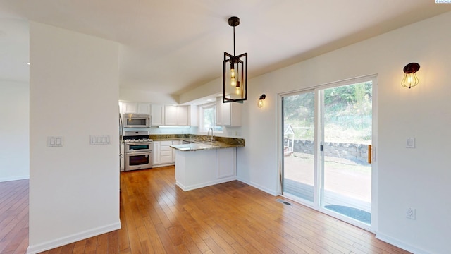 1220 SW Wadleigh Dr, Pullman, WA 99163 - kitchen with appliances with stainless steel finishes, white cabinets, a sink, light wood finished floors, and decorative light fixtures