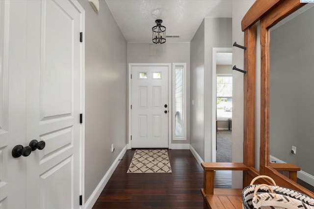 foyer featuring dark hardwood / wood-style floors and a textured ceiling