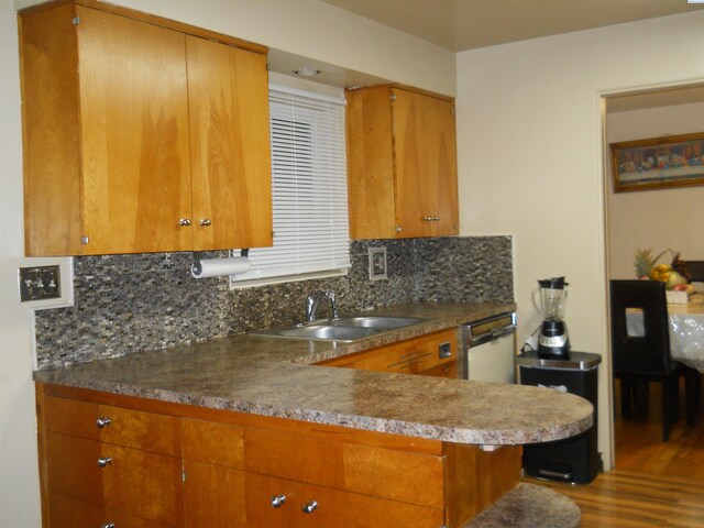 619 Grandview Ave, Sunnyside, WA 98944 - kitchen with a sink, decorative backsplash, wood finished floors, brown cabinets, and dishwasher