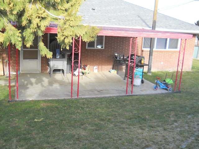 619 Grandview Ave, Sunnyside, WA 98944 - exterior space with a yard, roof with shingles, brick siding, and a patio area