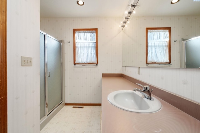 bathroom with a shower stall, a wealth of natural light, and wallpapered walls