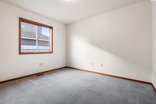 carpeted spare room with visible vents and baseboards