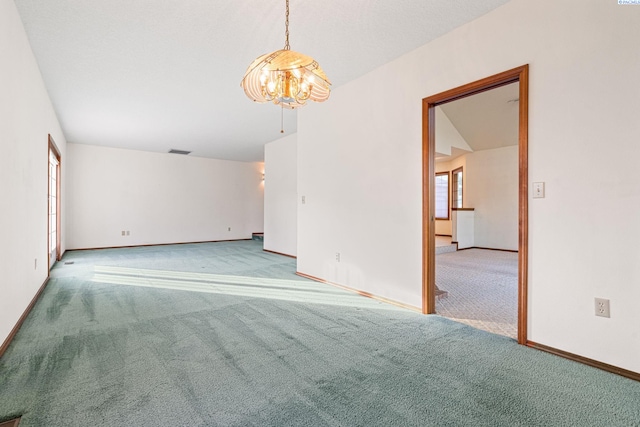 carpeted empty room with a chandelier, visible vents, and baseboards