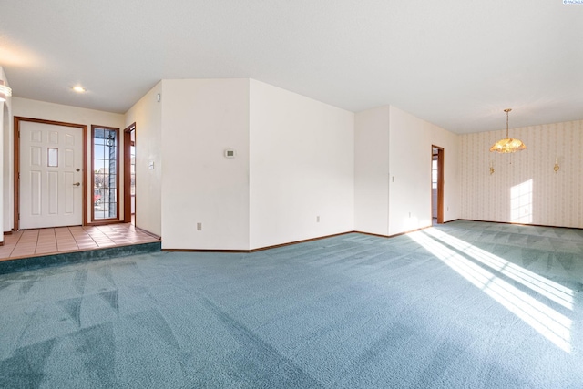 carpeted foyer entrance featuring wallpapered walls, baseboards, and tile patterned floors