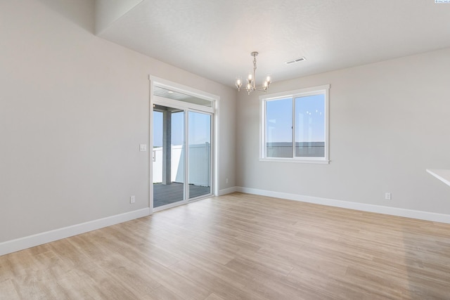 8801 Dusty Maiden Dr, Pasco, WA 99301 - unfurnished room with a chandelier and light wood-style flooring