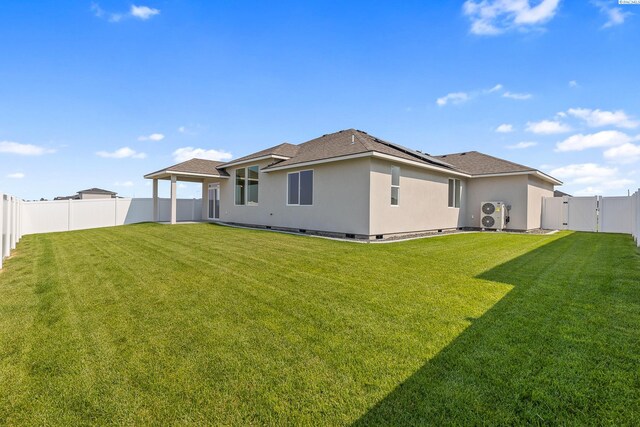 8801 Dusty Maiden Dr, Pasco, WA 99301 - back of house with roof mounted solar panels, stucco siding, a fenced backyard, a gate, and roof with shingles