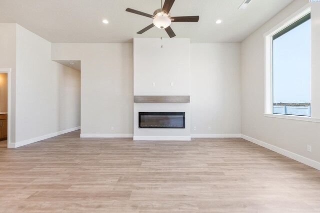 8801 Dusty Maiden Dr, Pasco, WA 99301 - unfurnished living room featuring a ceiling fan, a glass covered fireplace, light wood-style floors, and recessed lighting