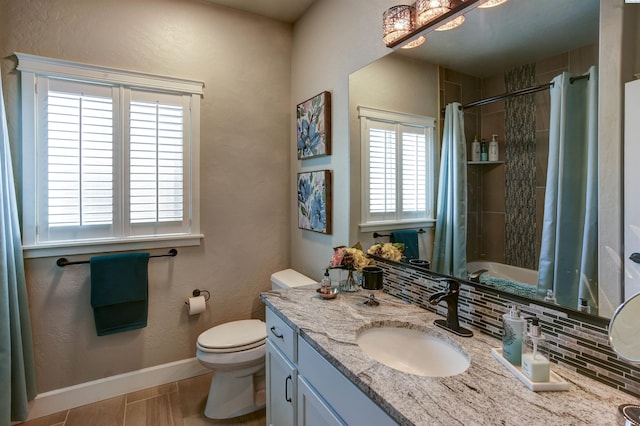 bathroom featuring baseboards, vanity, and toilet