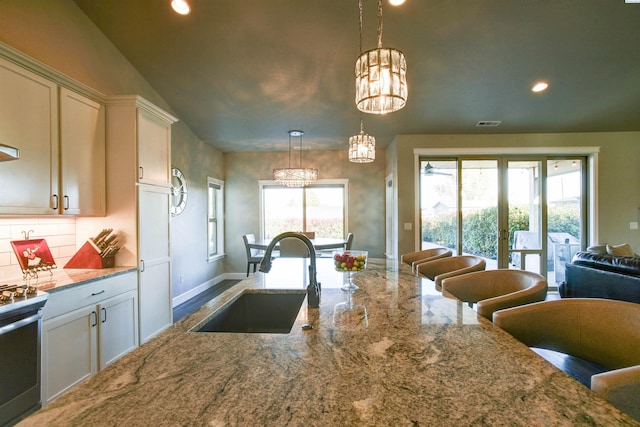 kitchen featuring plenty of natural light, a sink, electric range, and recessed lighting