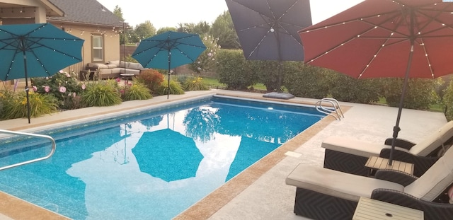 pool with outdoor lounge area and a patio