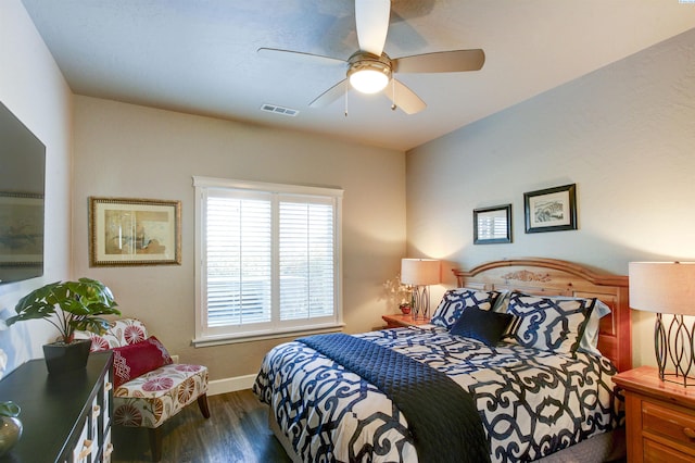 bedroom featuring visible vents, ceiling fan, baseboards, and wood finished floors