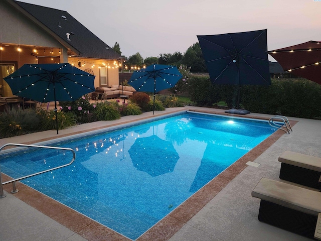 pool with outdoor lounge area and a patio