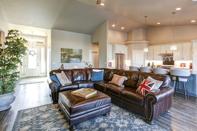 living area featuring high vaulted ceiling, a chandelier, wood finished floors, and recessed lighting