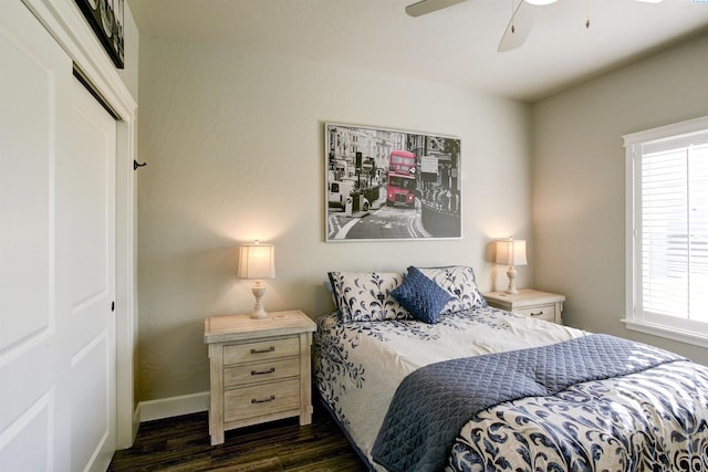 bedroom featuring dark wood-style floors, a closet, baseboards, and a ceiling fan