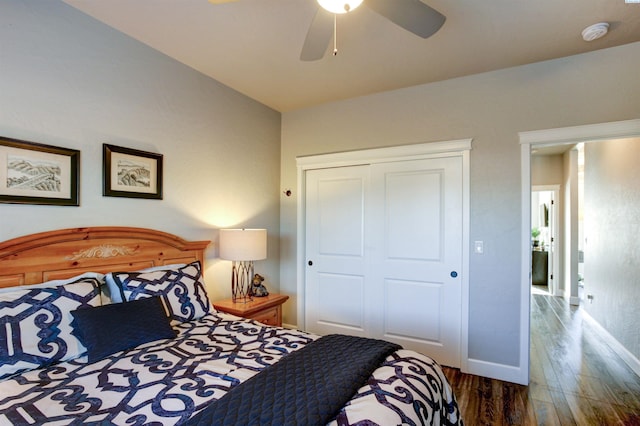 bedroom featuring a ceiling fan, a closet, baseboards, and wood finished floors