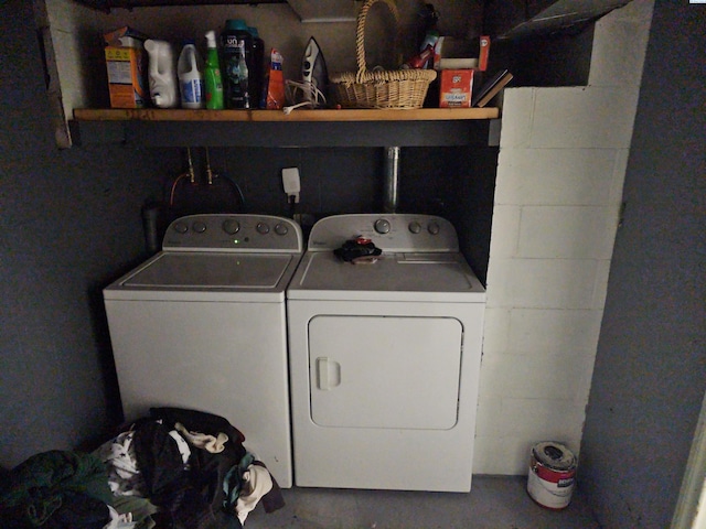 washroom with washer and dryer, laundry area, and concrete block wall