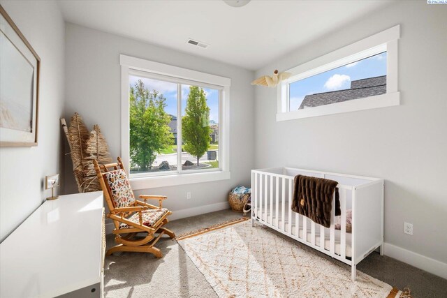 bedroom with carpet floors, baseboards, and a nursery area
