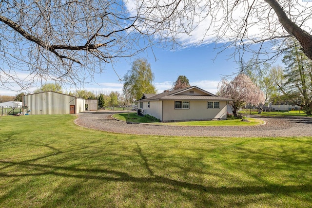 108 W 45th Ave, Kennewick, WA 99337 - view of side of home featuring an outbuilding, a yard, a detached garage, an outdoor structure, and driveway