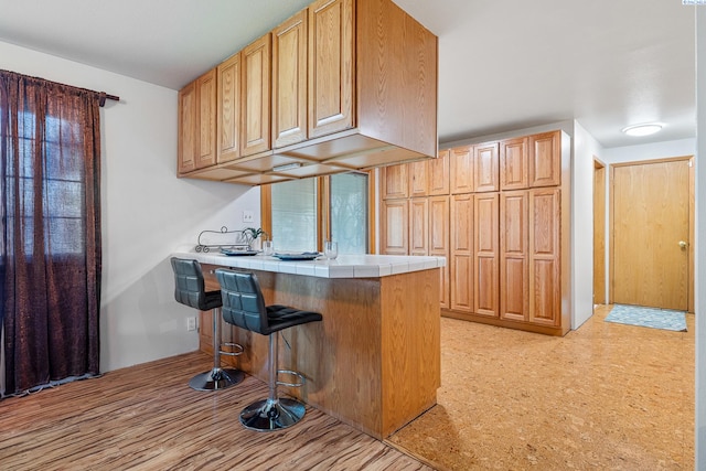 108 W 45th Ave, Kennewick, WA 99337 - kitchen with tile counters, light floors, a kitchen breakfast bar, and a peninsula