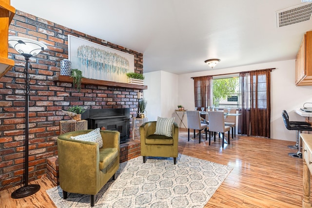 108 W 45th Ave, Kennewick, WA 99337 - living area with wood finished floors, a brick fireplace, and visible vents
