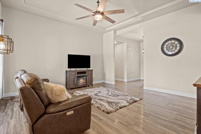 406 W 49th Ave, Kennewick, WA 99337 - living area featuring a ceiling fan, light wood-style flooring, baseboards, and a glass covered fireplace