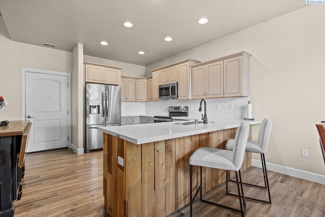 406 W 49th Ave, Kennewick, WA 99337 - kitchen featuring appliances with stainless steel finishes, a sink, a peninsula, light wood finished floors, and recessed lighting