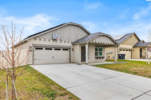 view of front of property featuring a garage, a front yard, and solar panels