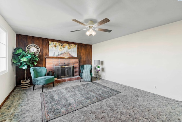 sitting room featuring a fireplace, wood walls, and carpet