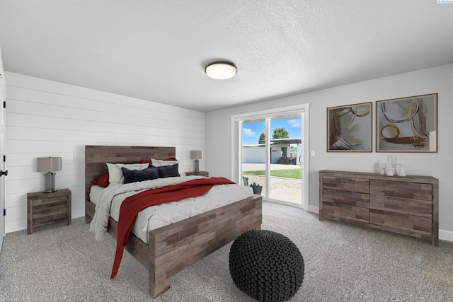 10401 N Mcdonald Rd, Prosser, WA 99350 - bedroom featuring access to outside, carpet, a textured ceiling, and wooden walls