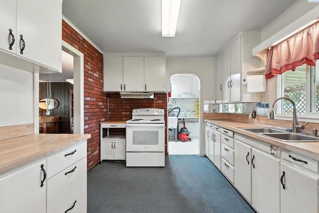 219 E 6th Ave, Kennewick, WA 99336 - kitchen featuring white electric range, under cabinet range hood, light countertops, white cabinets, and brick wall
