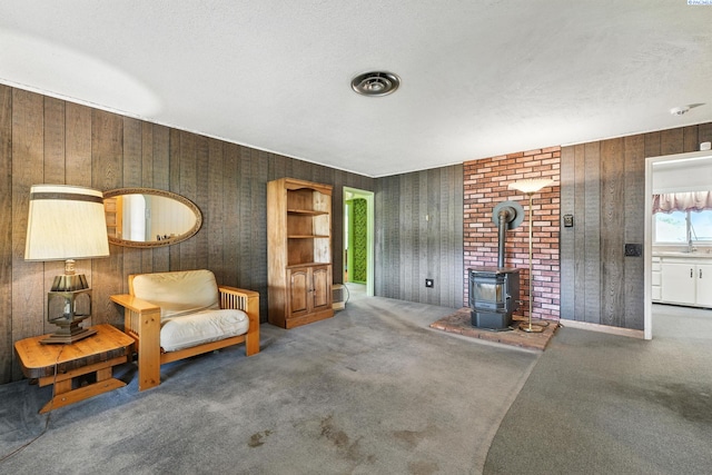 219 E 6th Ave, Kennewick, WA 99336 - sitting room featuring a wood stove, carpet, and a textured ceiling