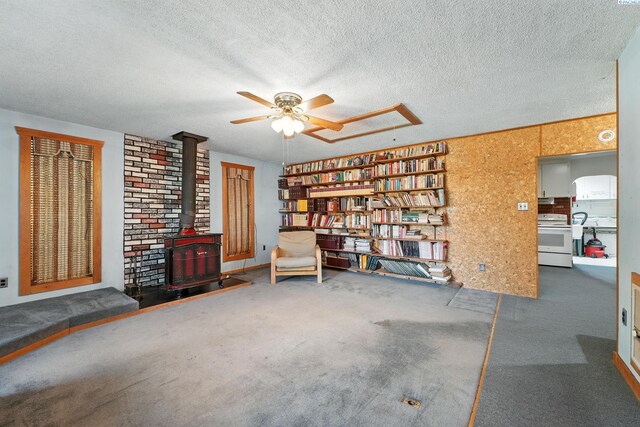 219 E 6th Ave, Kennewick, WA 99336 - sitting room with a wood stove, a ceiling fan, a textured ceiling, and carpet