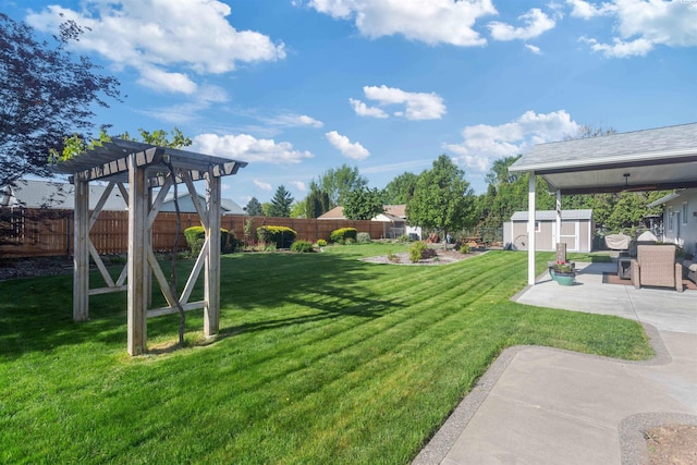 view of yard featuring a patio, a pergola, an outbuilding, and a fenced backyard