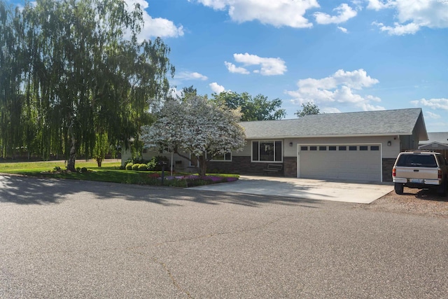 single story home with brick siding, driveway, and a garage