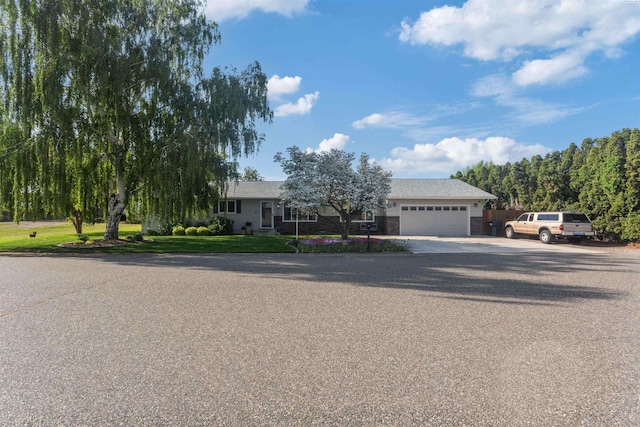 view of property hidden behind natural elements with a garage and concrete driveway