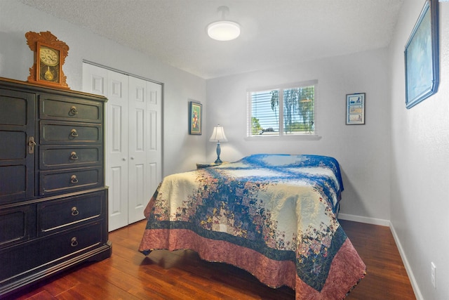 bedroom featuring a closet, baseboards, and dark wood-type flooring