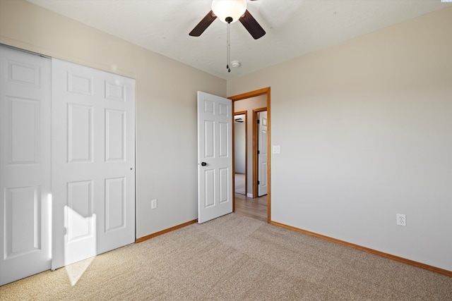 unfurnished bedroom with carpet, baseboards, ceiling fan, and a closet