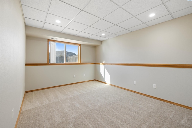 carpeted spare room featuring baseboards, a drop ceiling, and recessed lighting