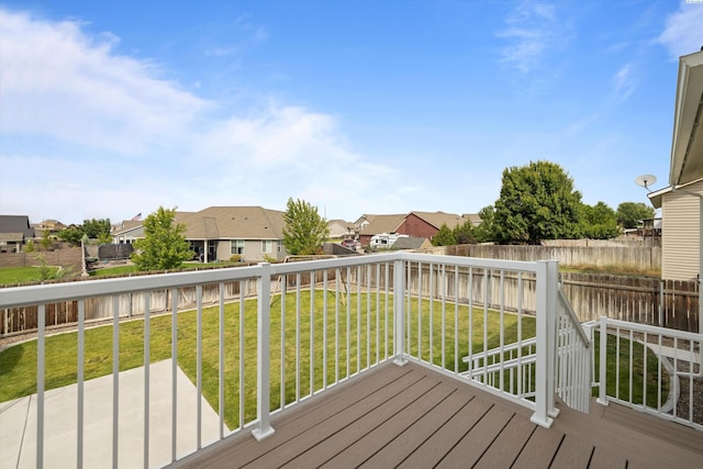 wooden terrace featuring a residential view, a fenced backyard, and a yard