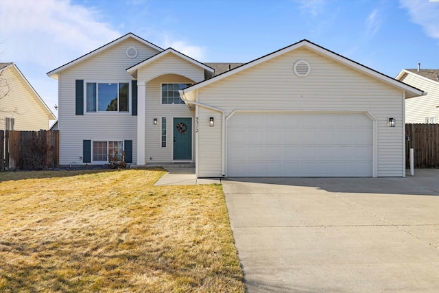 view of front facade with a front lawn, fence, driveway, and an attached garage