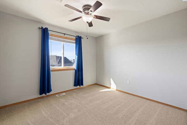 carpeted empty room with ceiling fan, visible vents, and baseboards