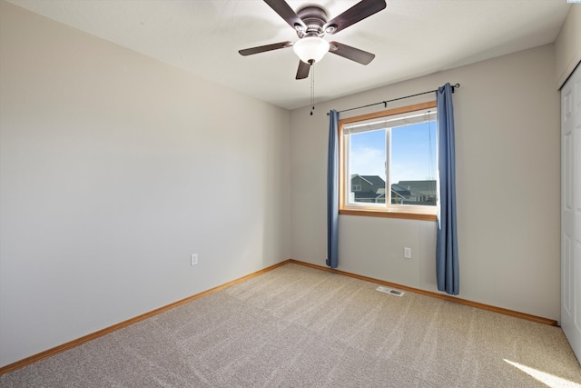 unfurnished room with baseboards, visible vents, ceiling fan, and carpet flooring