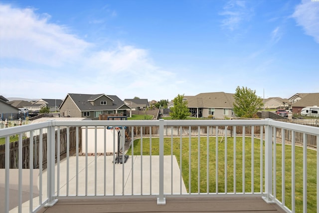 wooden terrace with a lawn, a fenced backyard, and a residential view