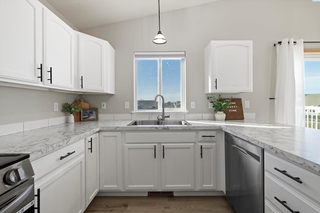 kitchen with appliances with stainless steel finishes, wood finished floors, hanging light fixtures, white cabinetry, and a sink