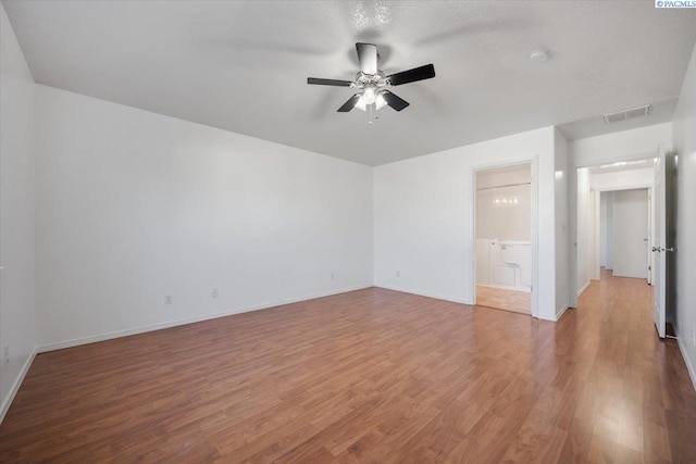 unfurnished room featuring light wood-type flooring, baseboards, visible vents, and a ceiling fan